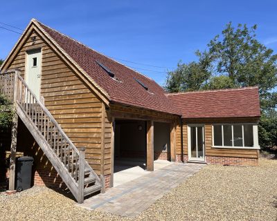 View of the external timber staircase leading to the first-floor storage area of the cartlodge and studio