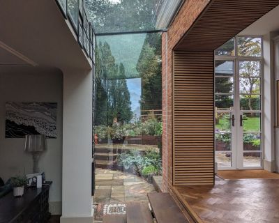 Modern glazed link block with glass walls connecting different sections of the property.