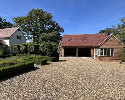 Wide shot of the cartlodge and surrounding landscape as seen from the far side of the driveway.