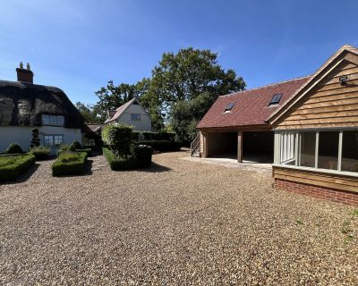 Wide shot of the cartlodge and surrounding landscape as seen from the far side of the driveway.