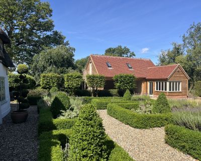New cartlodge and studio building viewed from the adjacent cottage, with landscaped garden in the foreground.