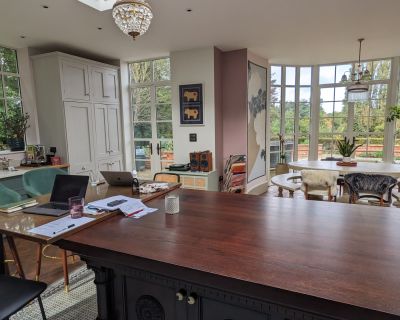 Luxury kitchen-diner interior with garden views and elegant furnishings.
