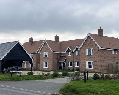 Street view of Phase 2 in the 20-house development, showcasing residential houses with green landscaping.