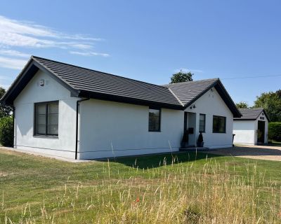 Updated 1980s bungalow featuring a new roof with integrated solar panels and contemporary design.