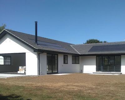 Backyard view of the modernised bungalow with a new patio area and landscaped lawn.