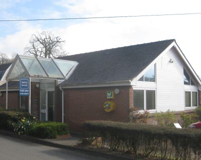 Original building of the old doctor's surgery with a brick finish and conservatory entrance.