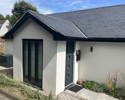 Close-up of the modernised porch extension with a dark grey door and large vertical window.